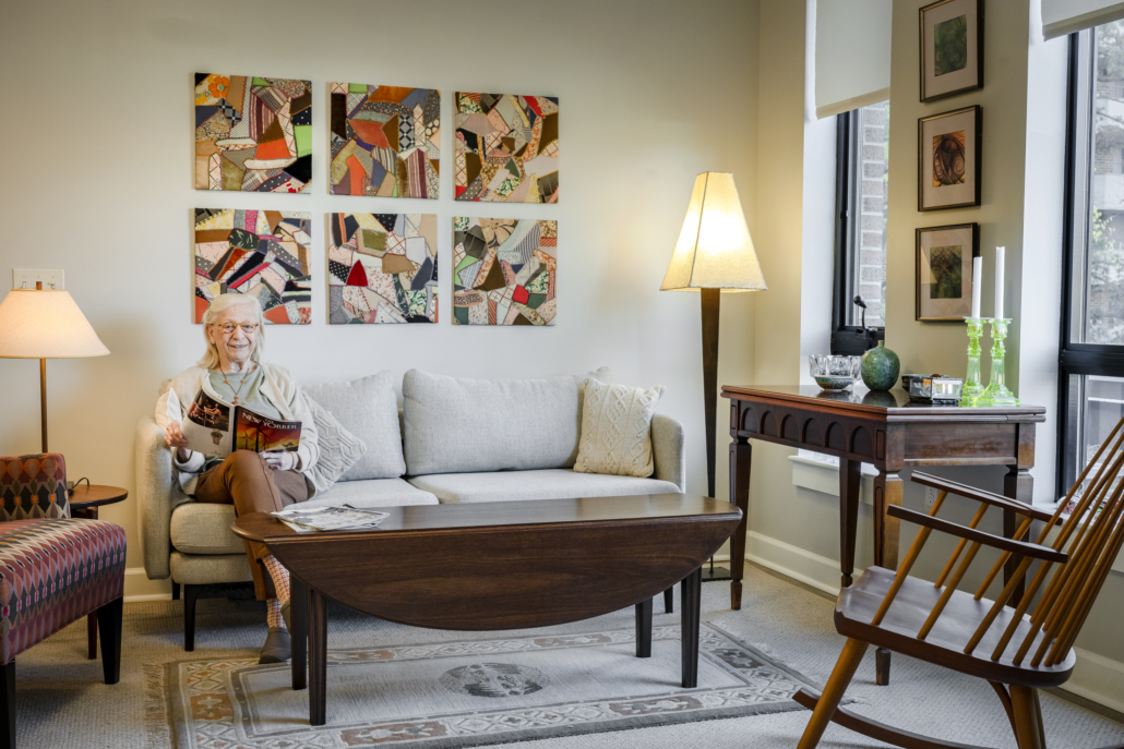 happy senior woman sitting on a couch in an independent senior living community