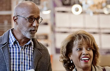 a senior man and woman talking and smiling looking off slightly to the right of the photo’s frame