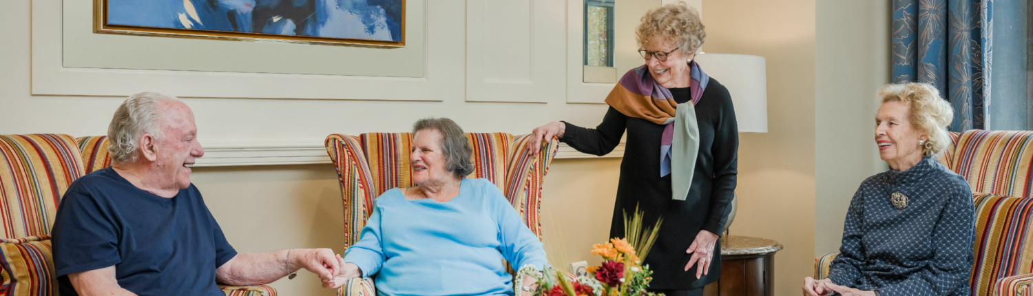 a group of four seniors talking together at Roland Park Place, a Baltimore senior living community