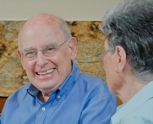 two seniors smiling and talking to each other