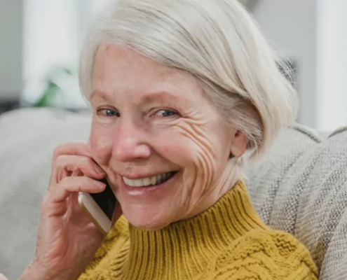 senior woman smiling at the camera while on the phone