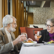 a senior man and woman having dinner together at a restaurant and talking