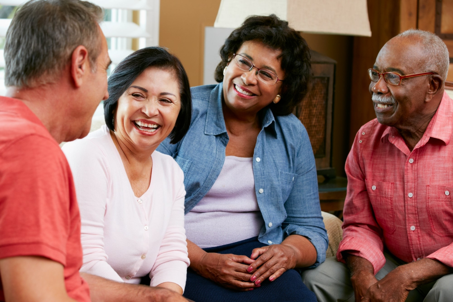 A group of 4 senior friends who are talking and socializing.