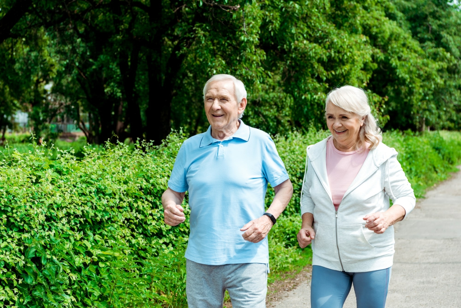 Healthy senior couple smiling and walking outside.