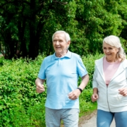 Healthy senior couple smiling and walking outside.