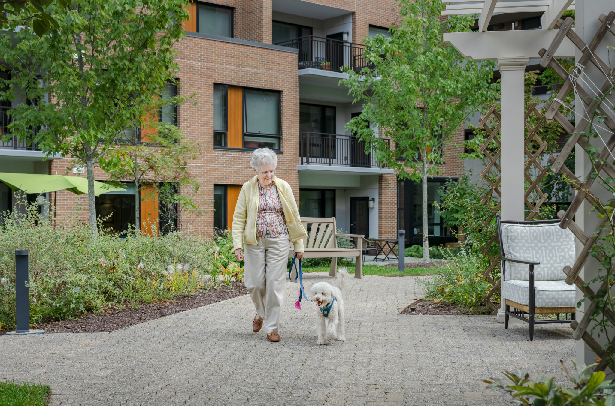 senior resident walking her dog at Roland Park Place, a senior living in Baltimore